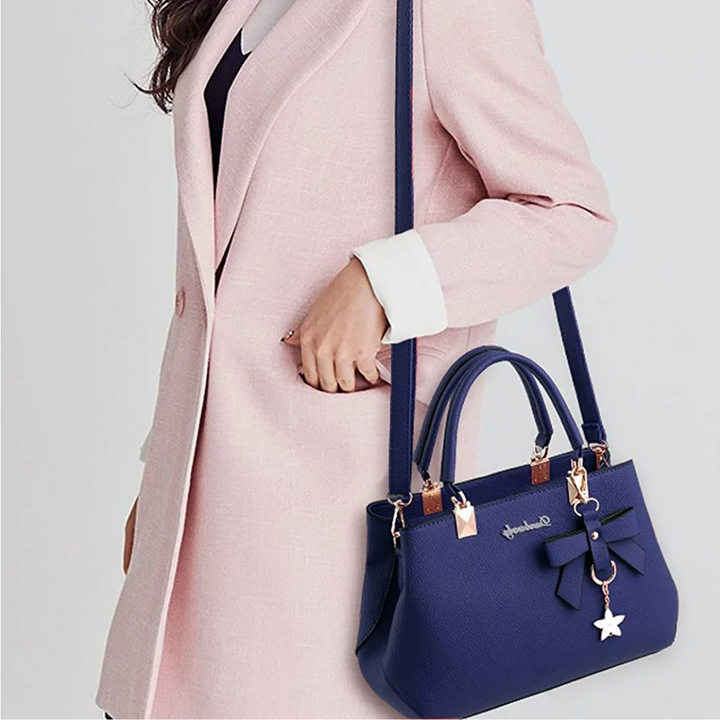 Detail van de charmante strik op een roze dames crossbody tas, elegant en van hoogwaardig kunstleer.