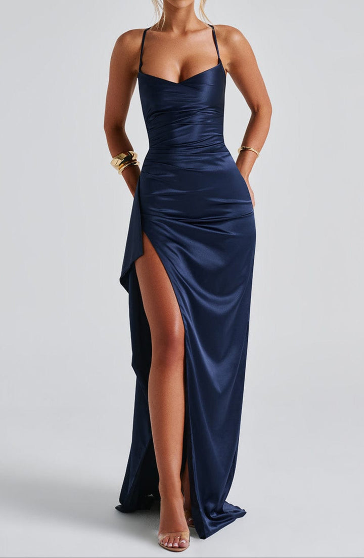 Dames maxi jurk in marineblauw, met een elegante split en delicate spaghettibandjes. Ideaal als feest- of zomerjurk.