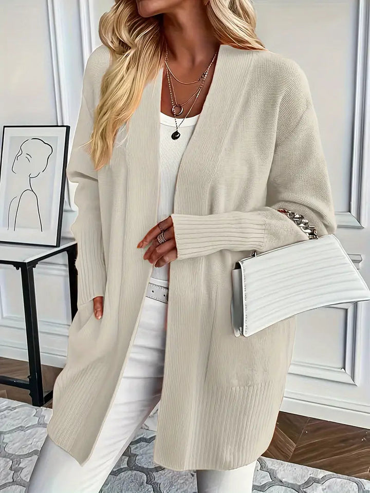 Elegant damesvest, gebreid met zakken en lange mouwen. Ideaal voor stijlvolle herfst- en winteroutfits.