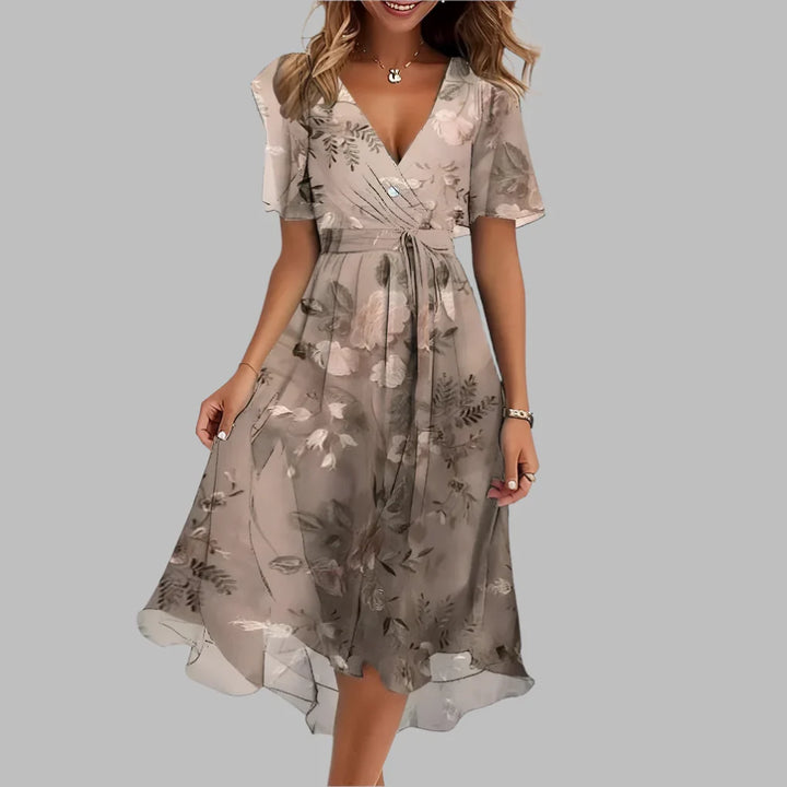 Dames geplooide lentejurk met opvallende bloemenprint, midi-lengte en elegante ruches details.