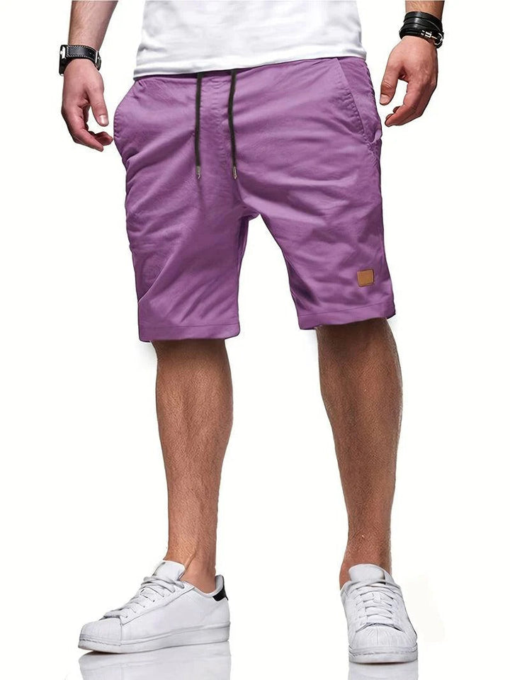 Model draagt een casual heren korte broek met trekkoord. Ontspannen stijl voor warme zomerdagen.