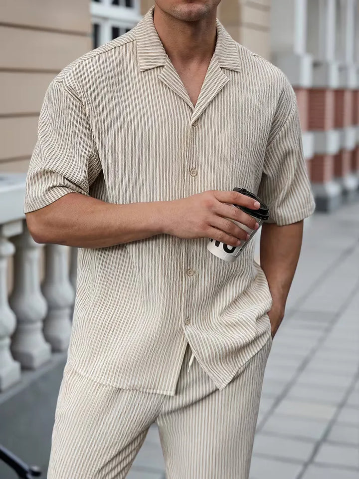 Beige tweedelige heren zomer kledingset met V-hals shirt en comfortabele broek, ideaal voor casual vakanties.