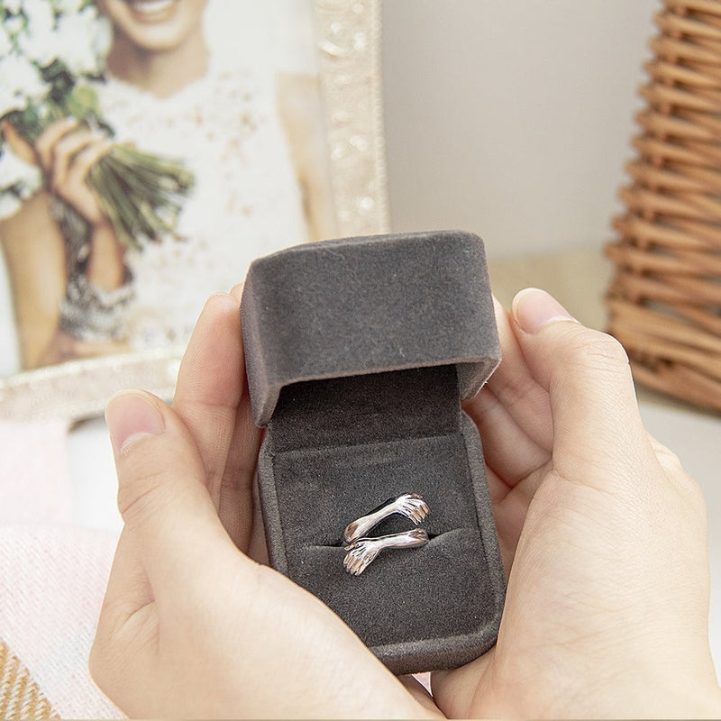 Elegante zilveren knuffelring voor dames, verstelbaar design, symbool van genegenheid en verbondenheid.
