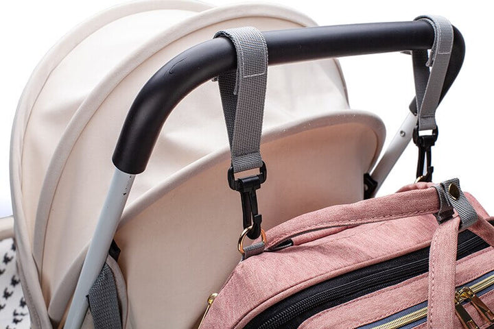Essentiële babyaccessoires: opvouwbaar babybed en luiertas in één handige reisrugzak voor ouders.