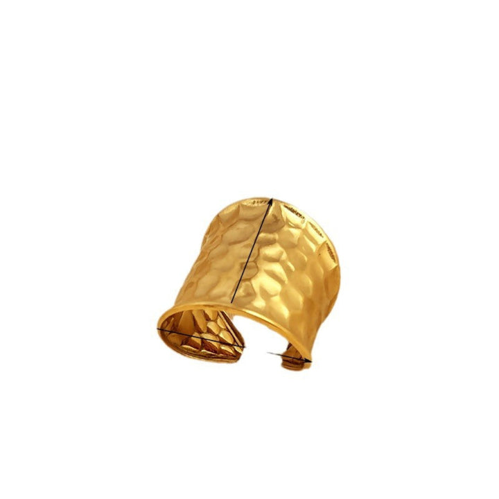 Statement sieraad: brede open unisex ring van goudkleurig edelstaal met opvallend gehamerd watergolfpatroon.