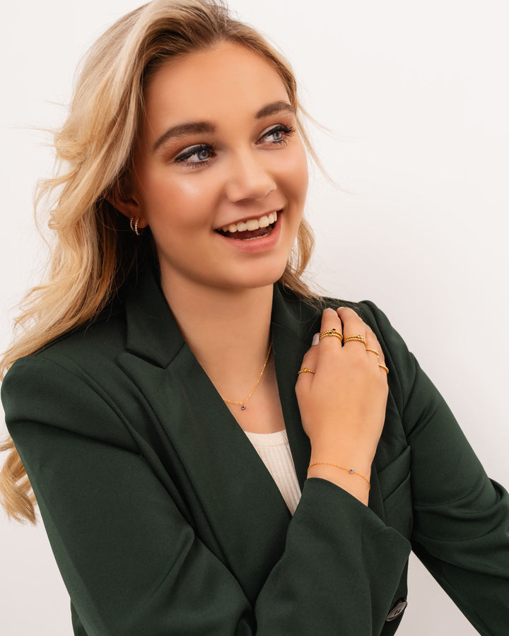 Exclusieve gouden dames armband met ronde geboortesteen, symbool van individualiteit en stijl.