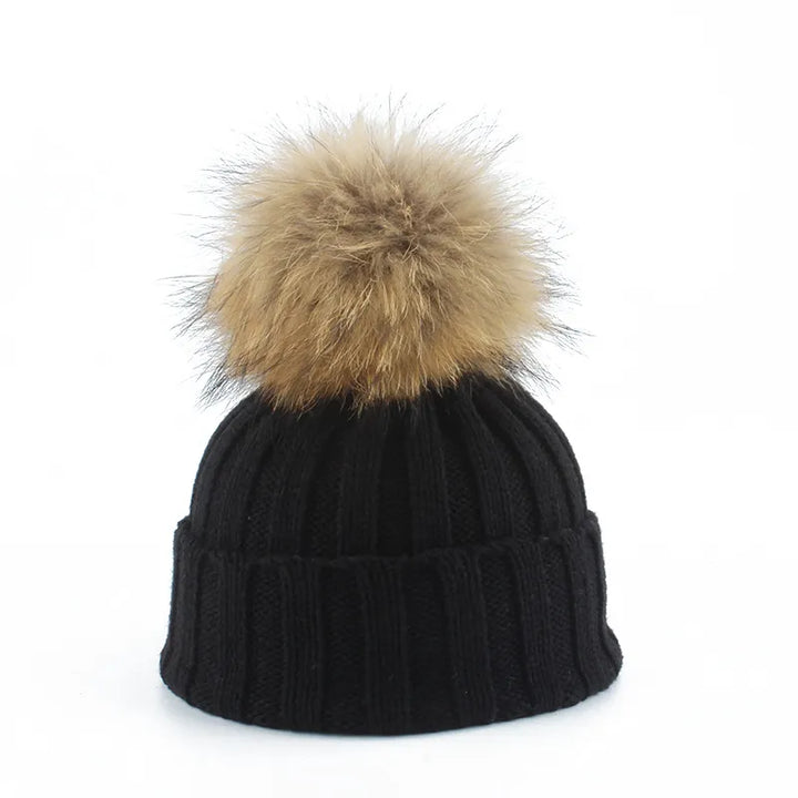 Dames gebreide wintermuts Felina met zachte nepbont pompon. Warme, stijlvolle muts voor wintermode.