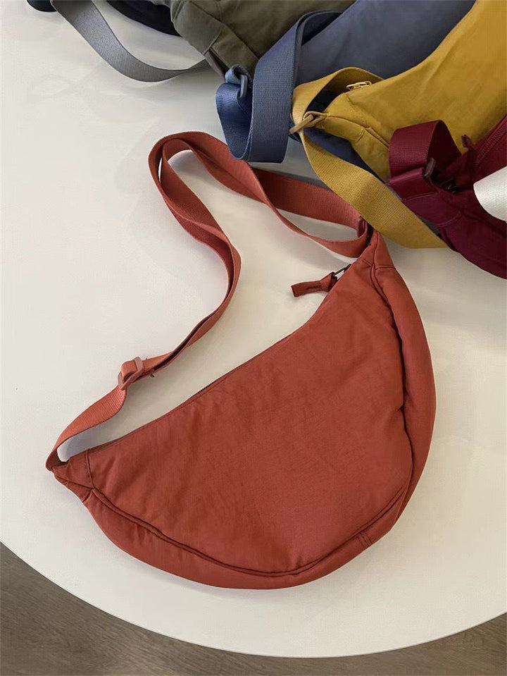 Zwarte gebogen dames schoudertas met verstelbare riem. Een must-have voor casual en elegante stijlen.