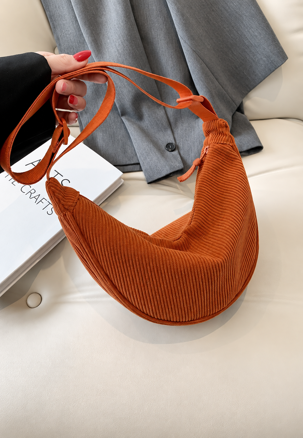 Compacte geribbelde halve maan schoudertas voor dames, draagbaar als crossbody of op de schouder.