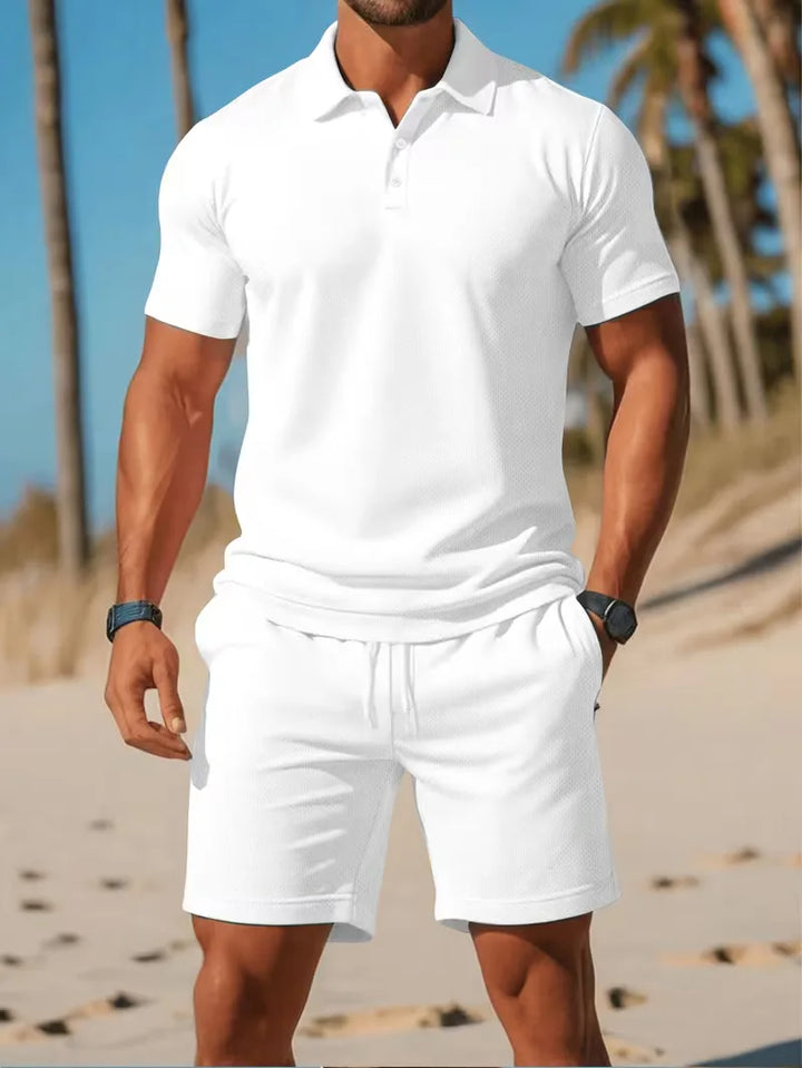 Heren zomerse tweedelige set: lichtblauwe V-hals polo en comfortabele witte shorts voor vakantie.