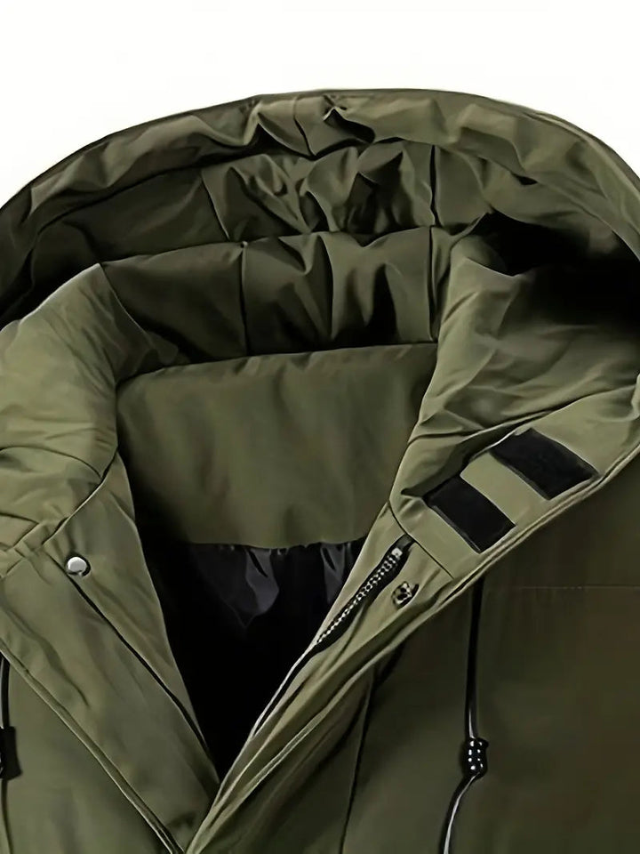 Close-up van het materiaal van een warme heren lange puffer winterjas met capuchon in zwart.