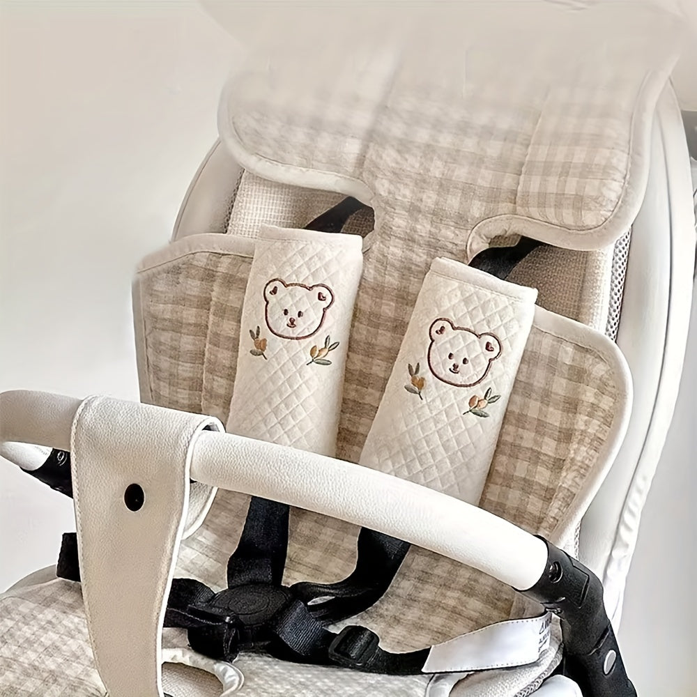 Detailopname van de zachte stof en het kleurrijke dierenmotief van de kinderwagen/autostoel schouderpads.