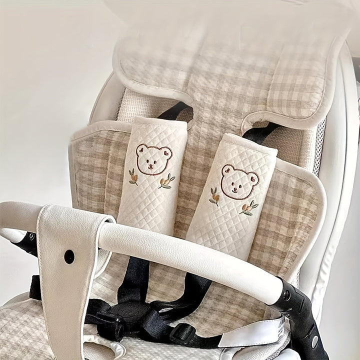Detailopname van de zachte stof en het kleurrijke dierenmotief van de kinderwagen/autostoel schouderpads.