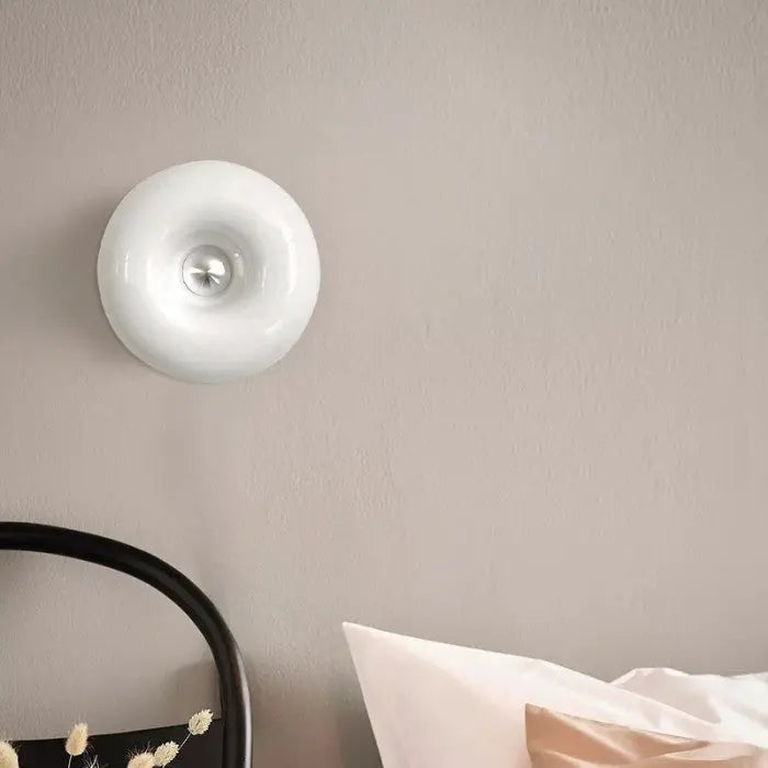 Compacte donut tafellamp met LED, wit glas voor een subtiele sfeerverlichting op nachtkastje.