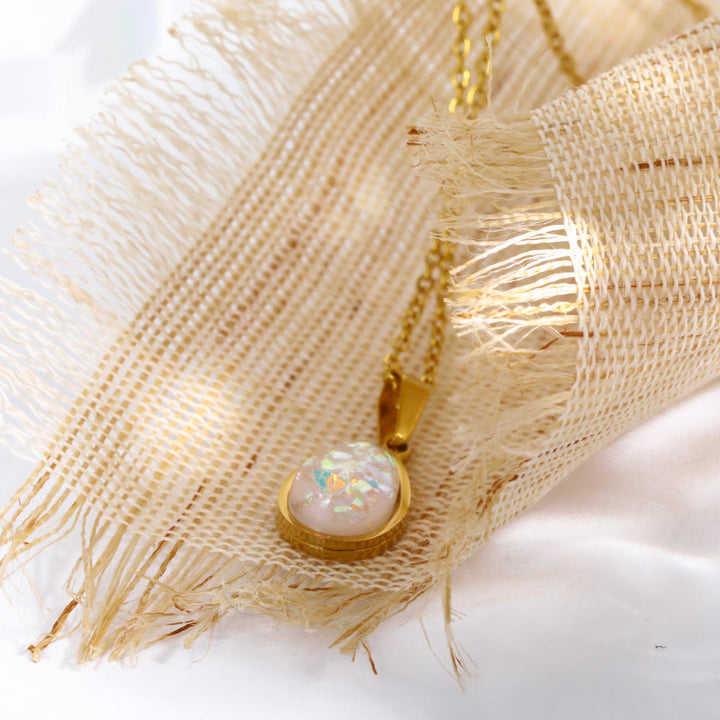Natuurlijke opaal druppel hanger aan een verfijnde 18K gouden ketting. Authentiek natuursteen sieraad.