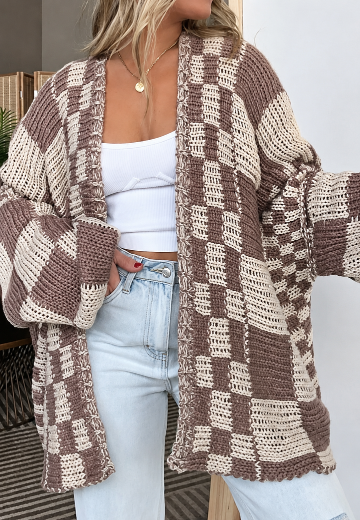 Close-up ruitjesmotief op dit beige en zwarte damesvest, met open voorkant en lange mouwen. Casual comfort.