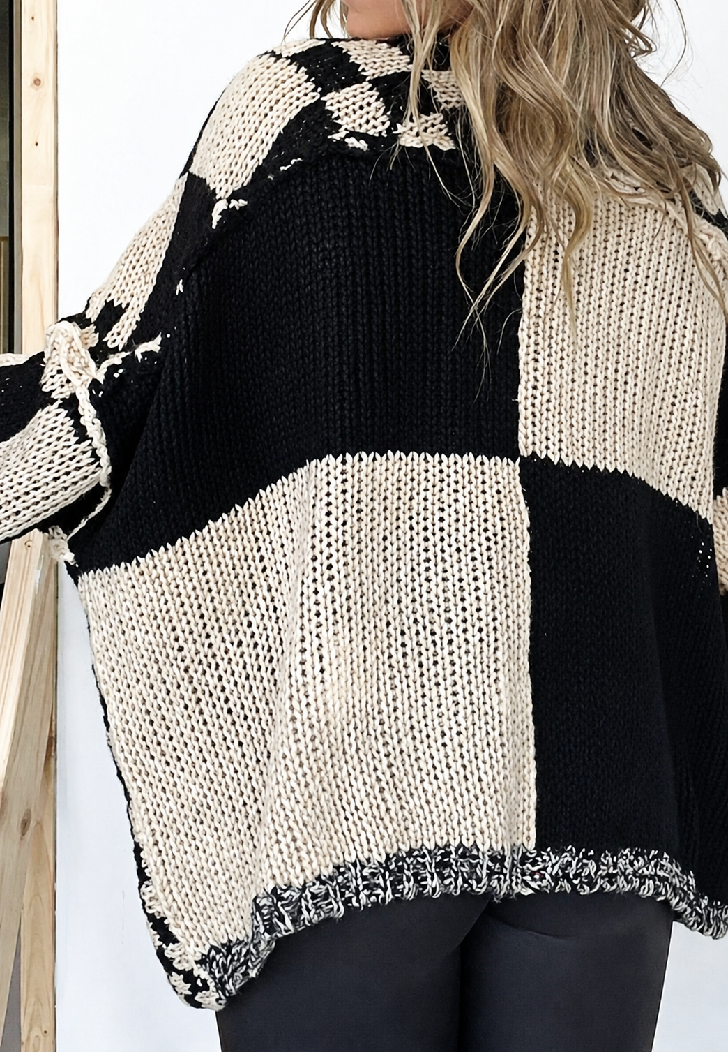 Geruit damesvest met lange mouwen, open voorkant en oversized pasvorm, in beige en zwart. Casual en modieus.