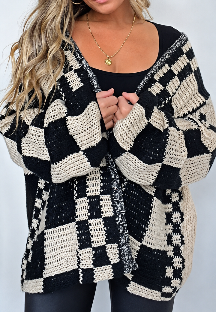 Trendy damesvest met beige/zwart ruitjespatroon, oversized pasvorm, lange mouwen en open voorkant. Modieus en warm.