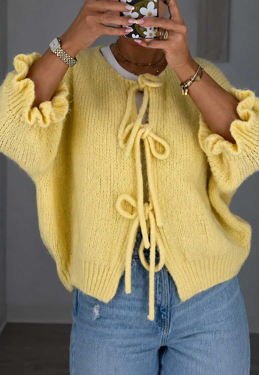 Chic geel damesvest met delicate strikjes, een elegante toevoeging aan elke herfst- of lenteoutfit.