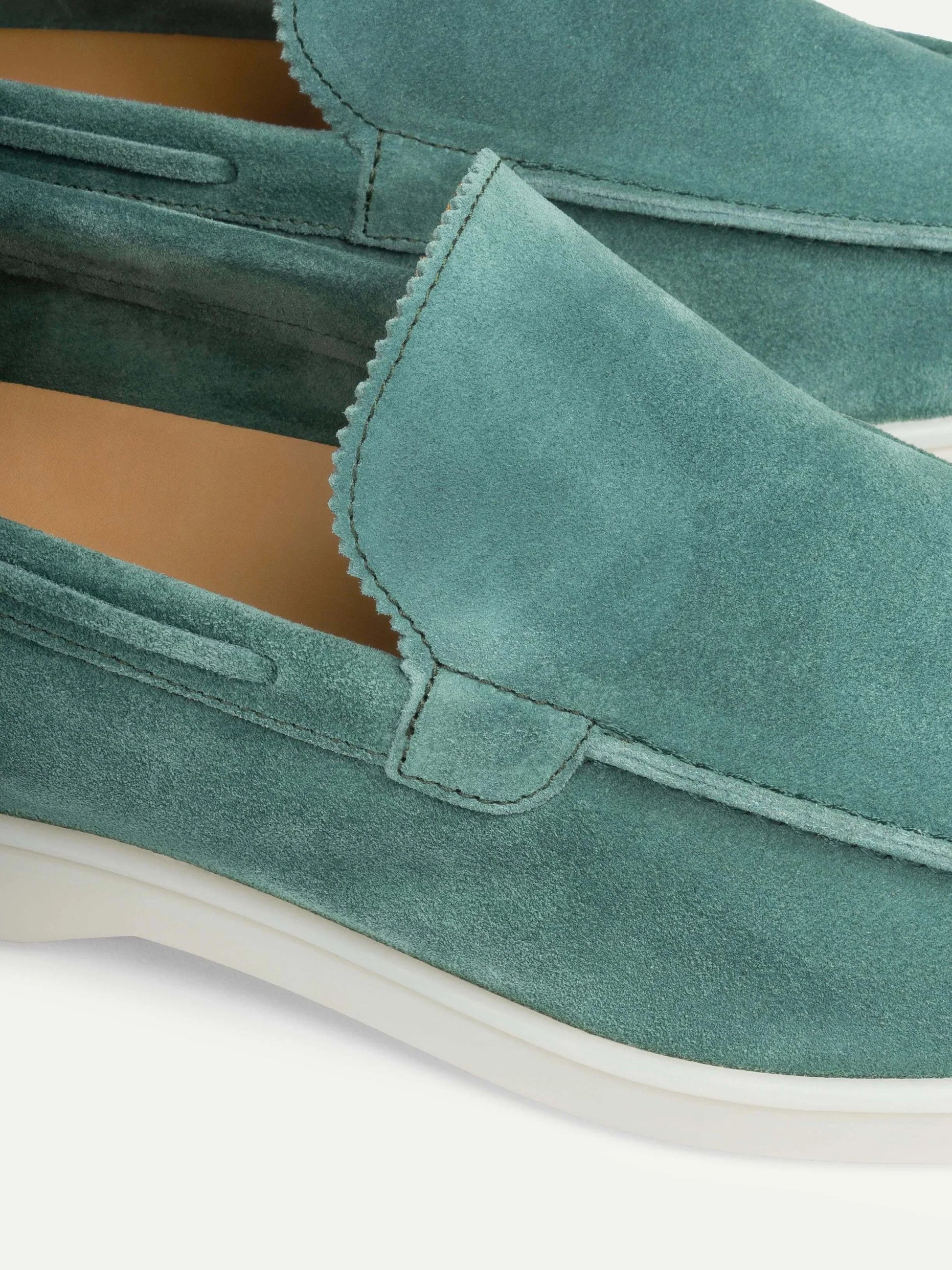 "Casual suède-look herenschoen met moderne witte zool; instapmodel zonder veters voor comfort en stijl."