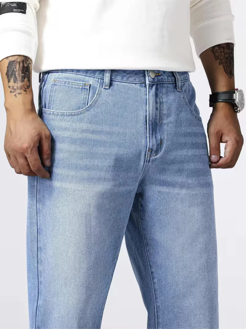 Man draagt blauwe loose fit jeans met rechte pijp. Perfect voor een casual dagelijkse streetwear outfit.