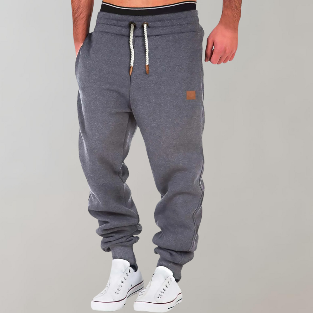 "Comfortabele heren joggingbroek met baggy pasvorm, grijs van kleur, verstelbare tailleband, ideaal voor sport en casual."