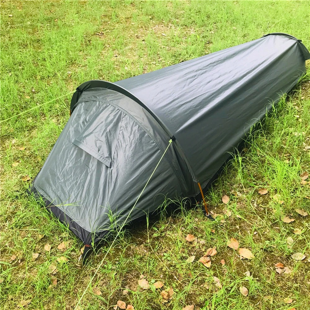 Ultralichte groene 1-persoons trekking tent mvb26 naast een rugzak, perfect voor solo avonturen.