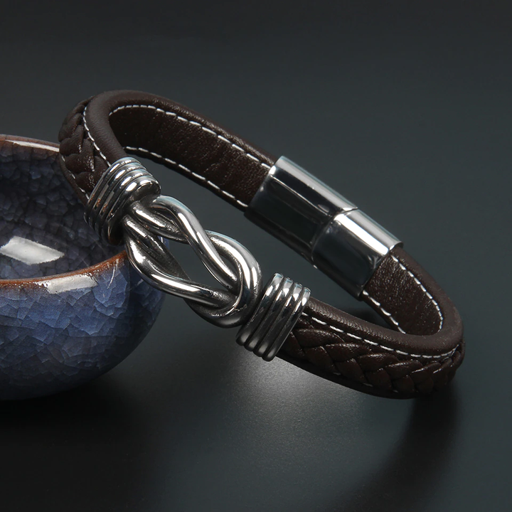 Stijlvolle unisex infinity armband van bruin leer, met unieke knoopdetails. Trendy accessoire.