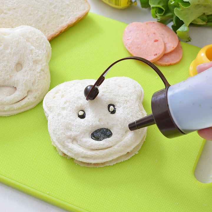 Lachend kind steekt brood uit met een beer-vormige sandwich uitsteekvorm, plezierig koken.