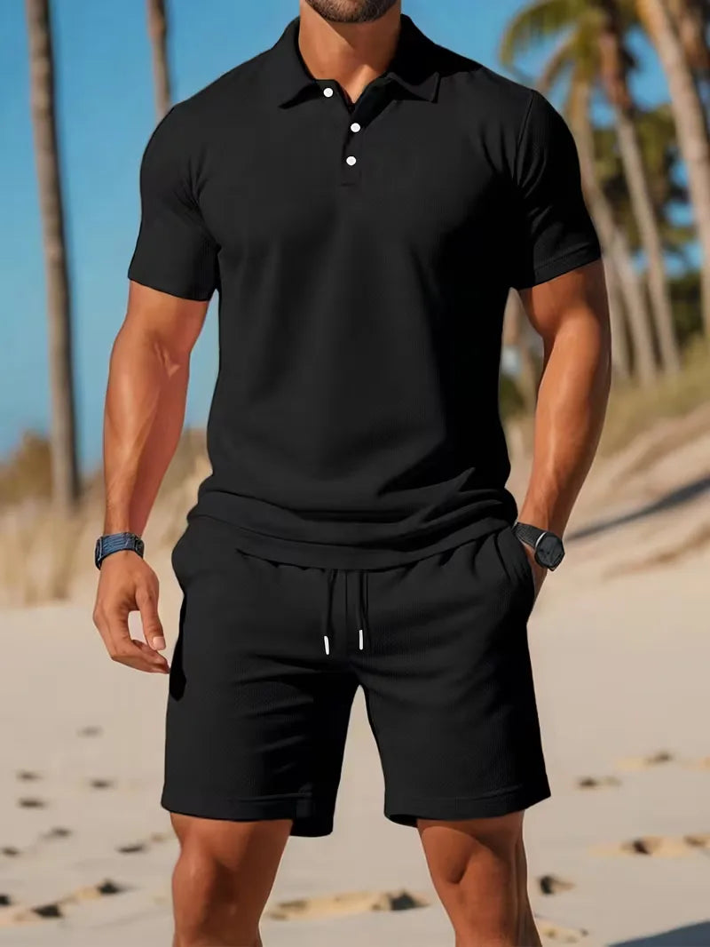 Tweedelige heren outfit voor de zomer: lichtblauwe polo en witte shorts, ideaal voor ontspanning.