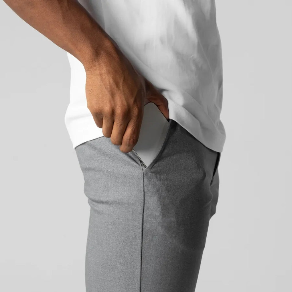 Close-up van de zachte katoenmix stof van de grijze heren chino. Toont de textuur en hoogwaardige kwaliteit.