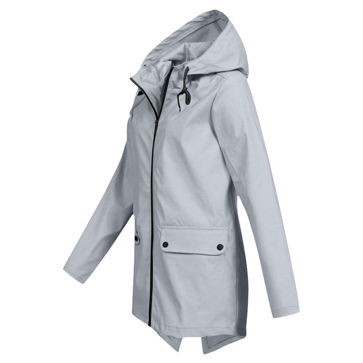 Vrouw wandelt in stijlvolle halflange dames anorak jas met capuchon, ideaal voor lente/herfst.