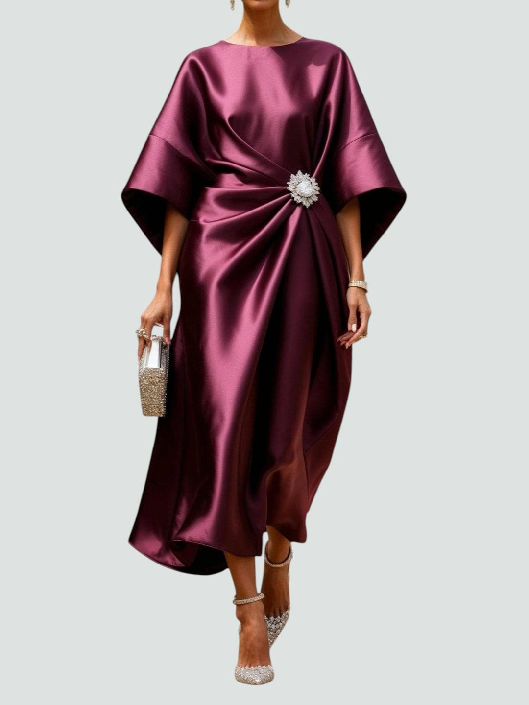 Elegante midi feestjurk met oversized pasvorm, vleermuismouwen en chique broche detail, perfect voor dames.