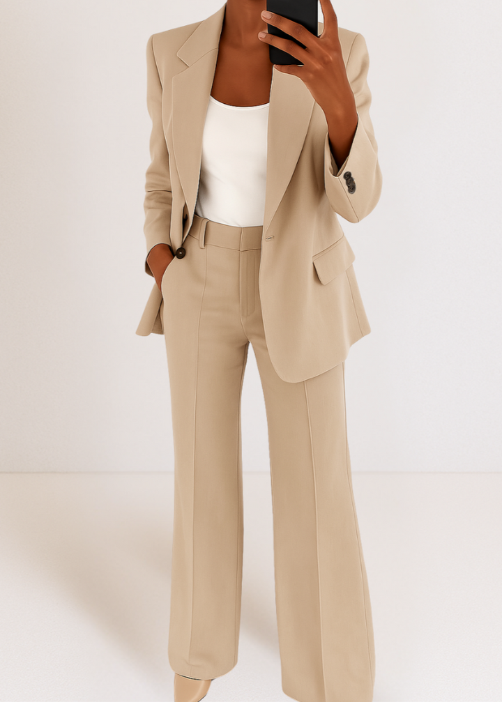 Tweedelig roze damespak: elegante blazer en wijde pijpen broek met reverskraag. Een modieuze kantooroutfit.