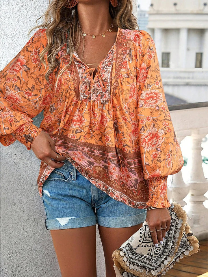 Dames bloemenblouse met lange mouwen. Elegante en vrouwelijke top met kleurrijke bloemenprint.