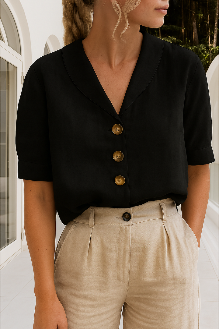 Verfijnde damesblouse, korte mouw, sjaalkraag en complete knoopsluiting. Casual en elegant design.