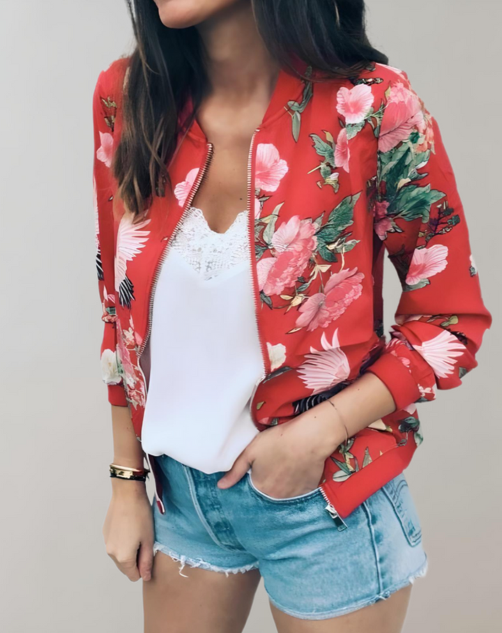 Close-up van de gedetailleerde bloemenprint op dit trendy dames bomberjack, levendige kleuren.
