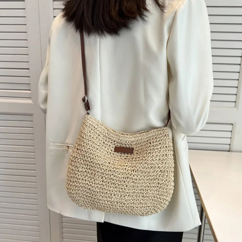 Praktische dames schoudertas met verstelbare riem, geschikt als crossbody en afgewerkt met vlechtwerk.