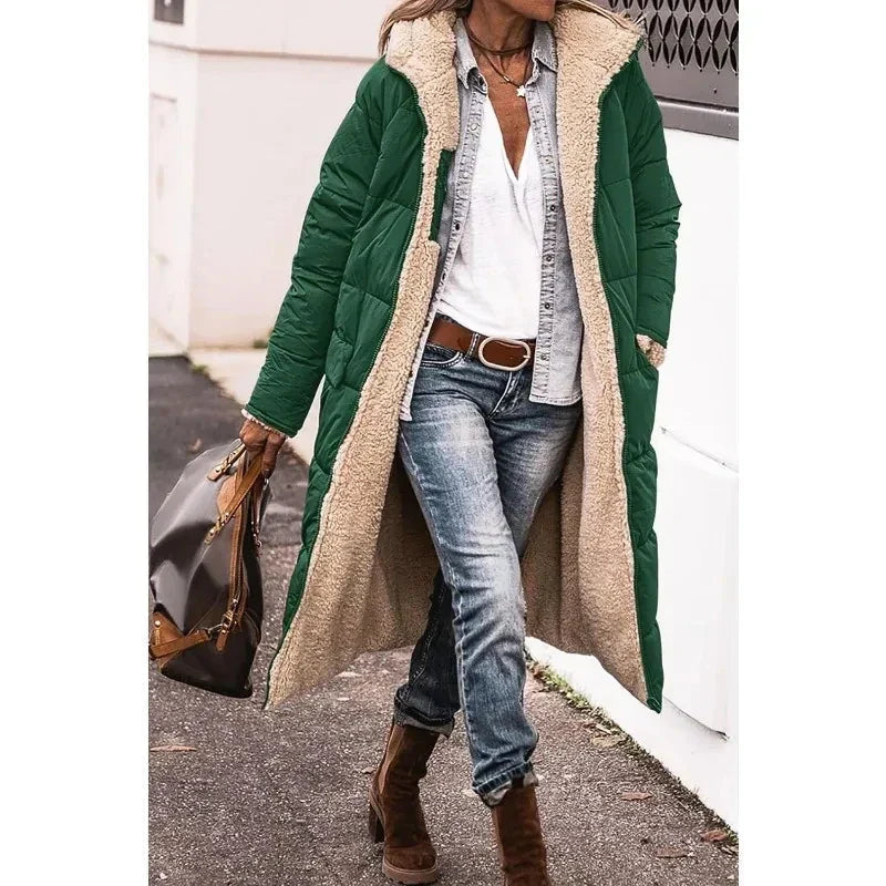 Model draagt lange dames pufferjas met capuchon. Een comfortabele en modieuze winterjas voor koude dagen.