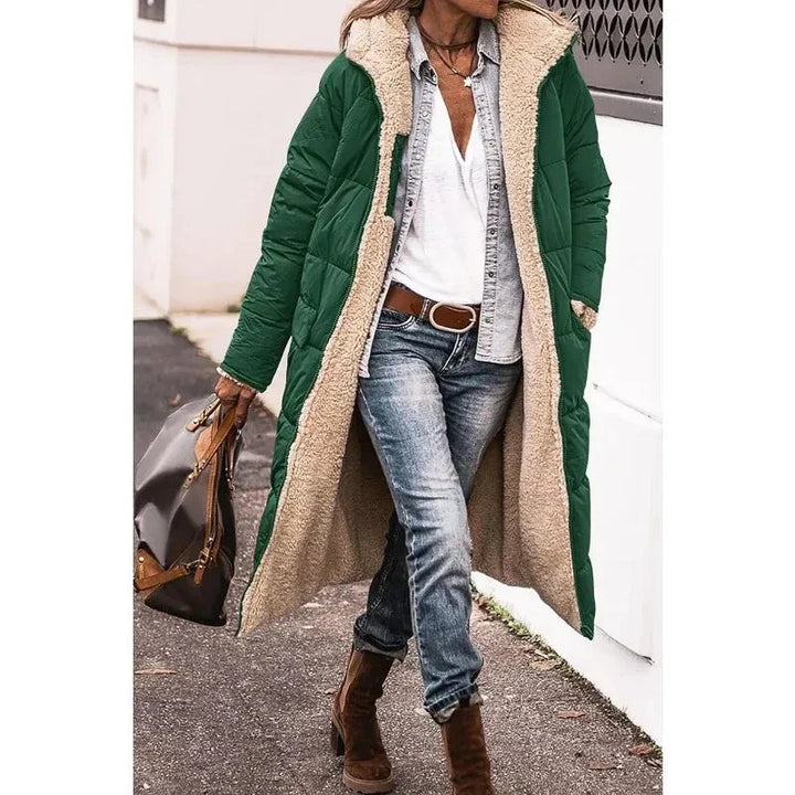 Model draagt lange dames pufferjas met capuchon. Een comfortabele en modieuze winterjas voor koude dagen.