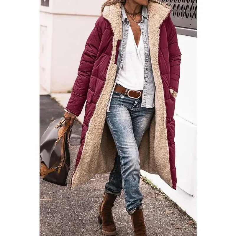 Detail van de capuchon op deze lange dames pufferjas. Essentiële warme winterjas voor comfort en mode.