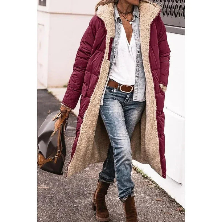 Detail van de capuchon op deze lange dames pufferjas. Essentiële warme winterjas voor comfort en mode.