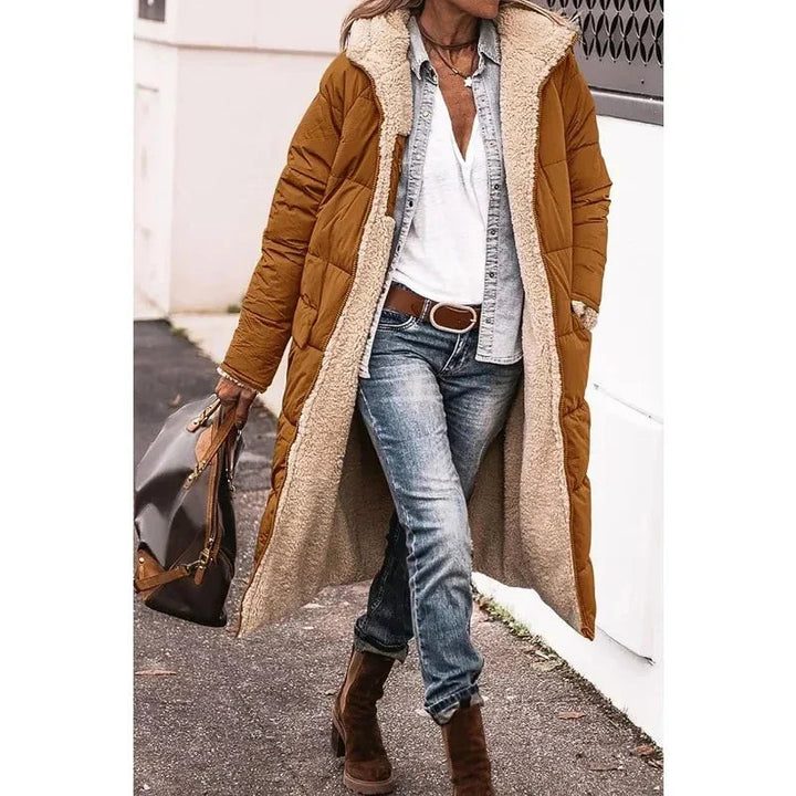 Elegante dames lange pufferjas met capuchon. Deze trendy winterjas biedt optimale warmte en stijl.