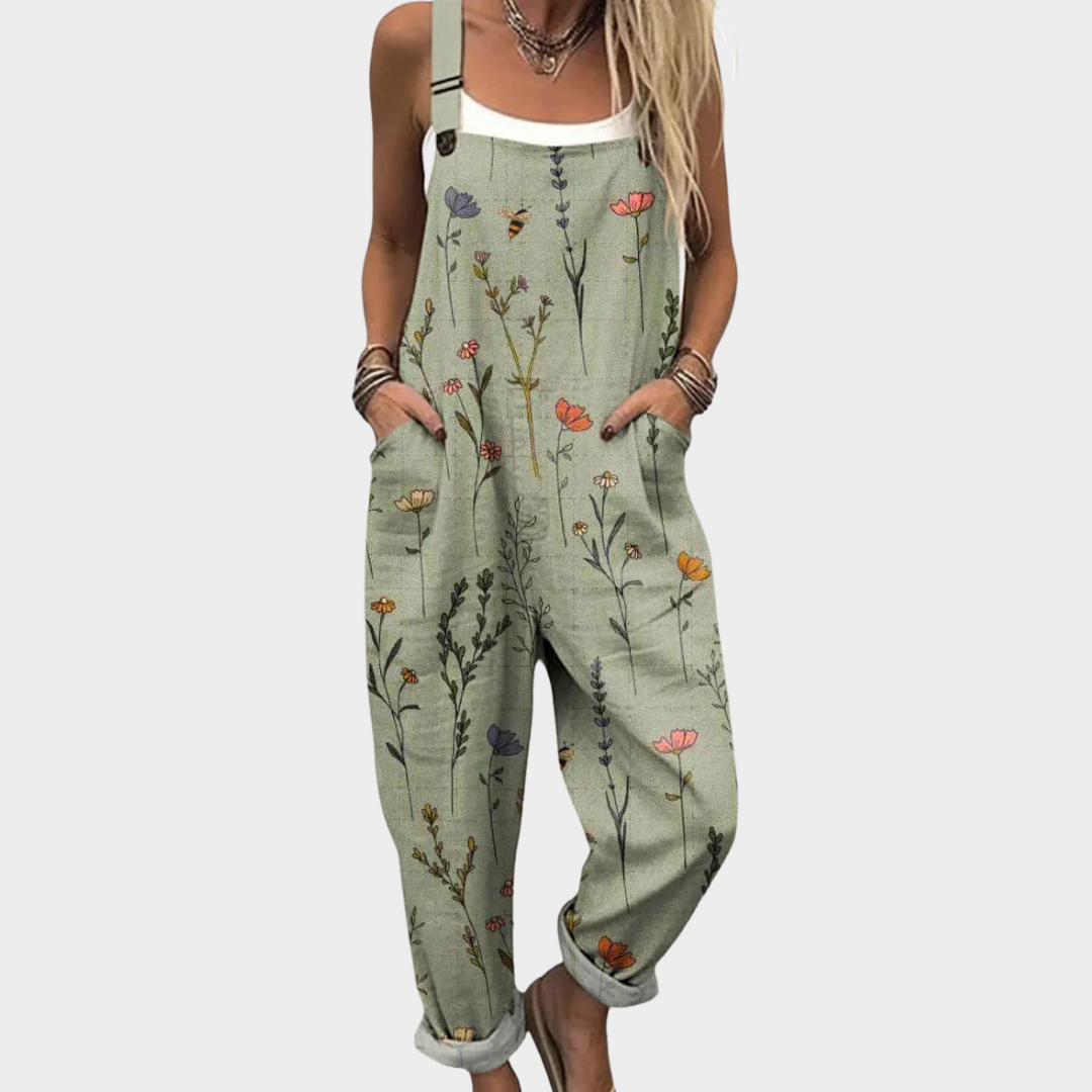 Comfortabele groene dames jumpsuit met botanische bloemenprint, zijzakken en verstelbare schouderbanden.