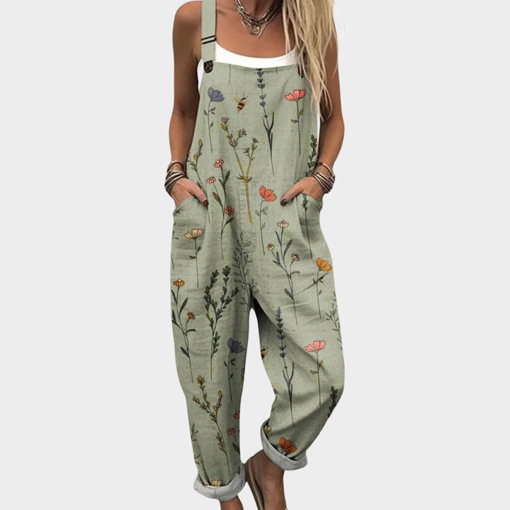 Comfortabele groene dames jumpsuit met botanische bloemenprint, zijzakken en verstelbare schouderbanden.
