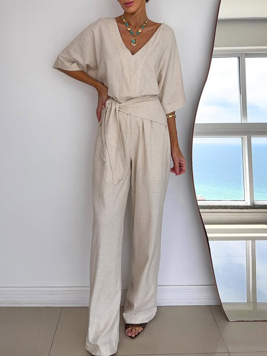 Chique dames jumpsuit met elegante V-hals, wijde pijpen en flatterende vleermuismouwen. Inclusief strikceintuur.