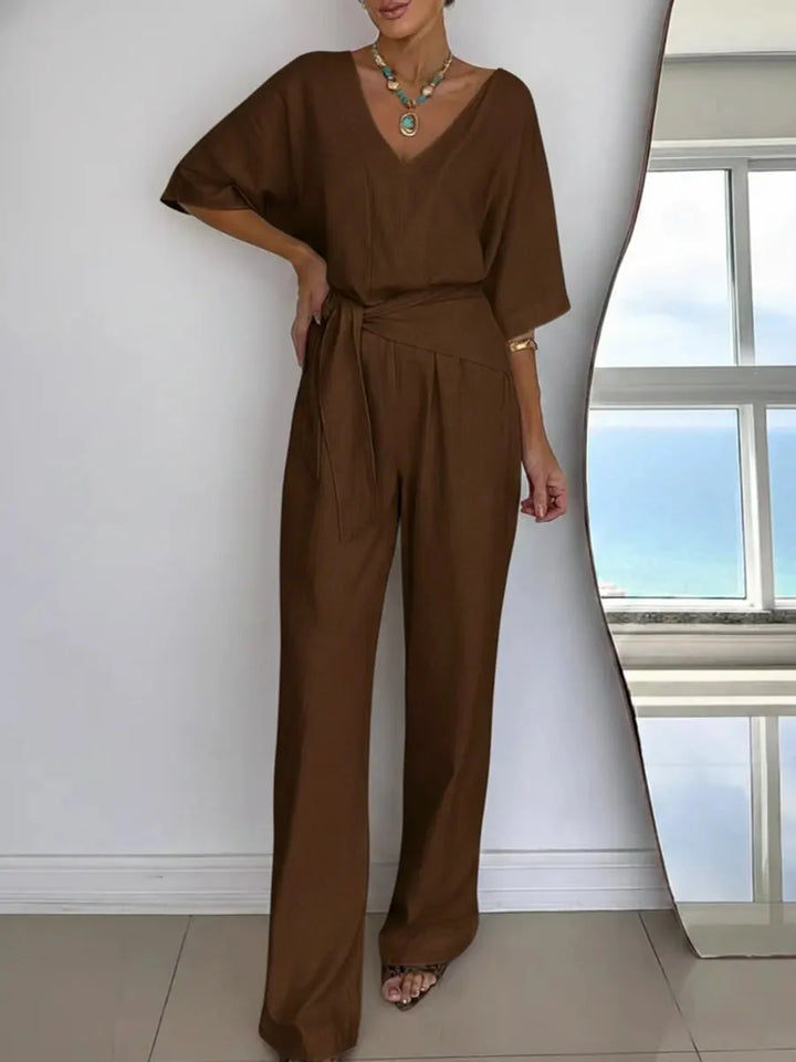 Wijde pijp dames jumpsuit, enkellang, met V-hals, vleermuismouwen en chique strikceintuur. Casual of feestelijk.