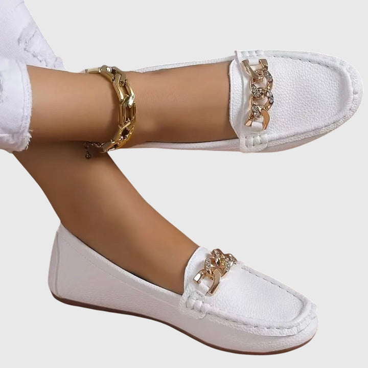 Witte dames loafers met gouden kettingdetail. Stijlvolle instapschoenen met platte zool, casual chic.