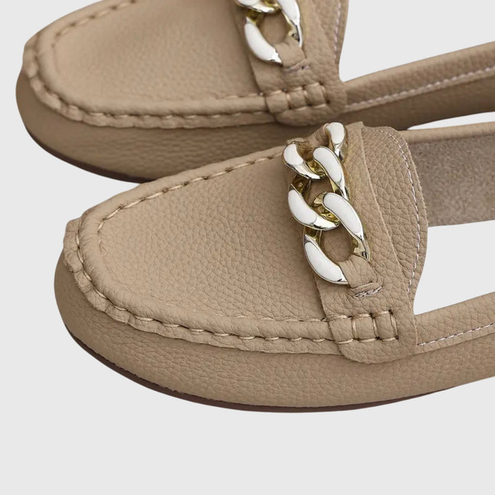 Dames instapschoenen: zwarte loafers met opvallend gouden kettingdetail en comfortabele platte zool.