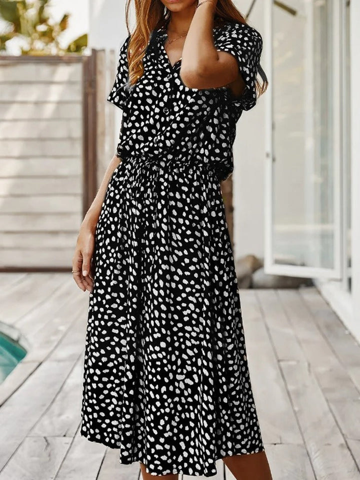 Zomerse dames midi jurk met V-hals, korte mouw en trendy stippenprint. Ideaal voor warm weer.